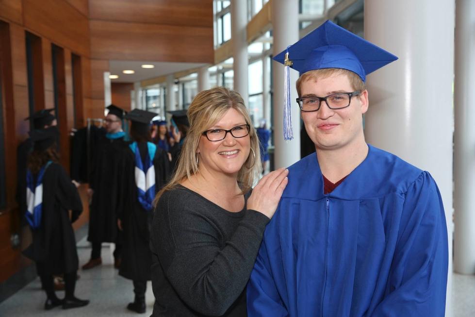 woman next to man dressed in cap and gown